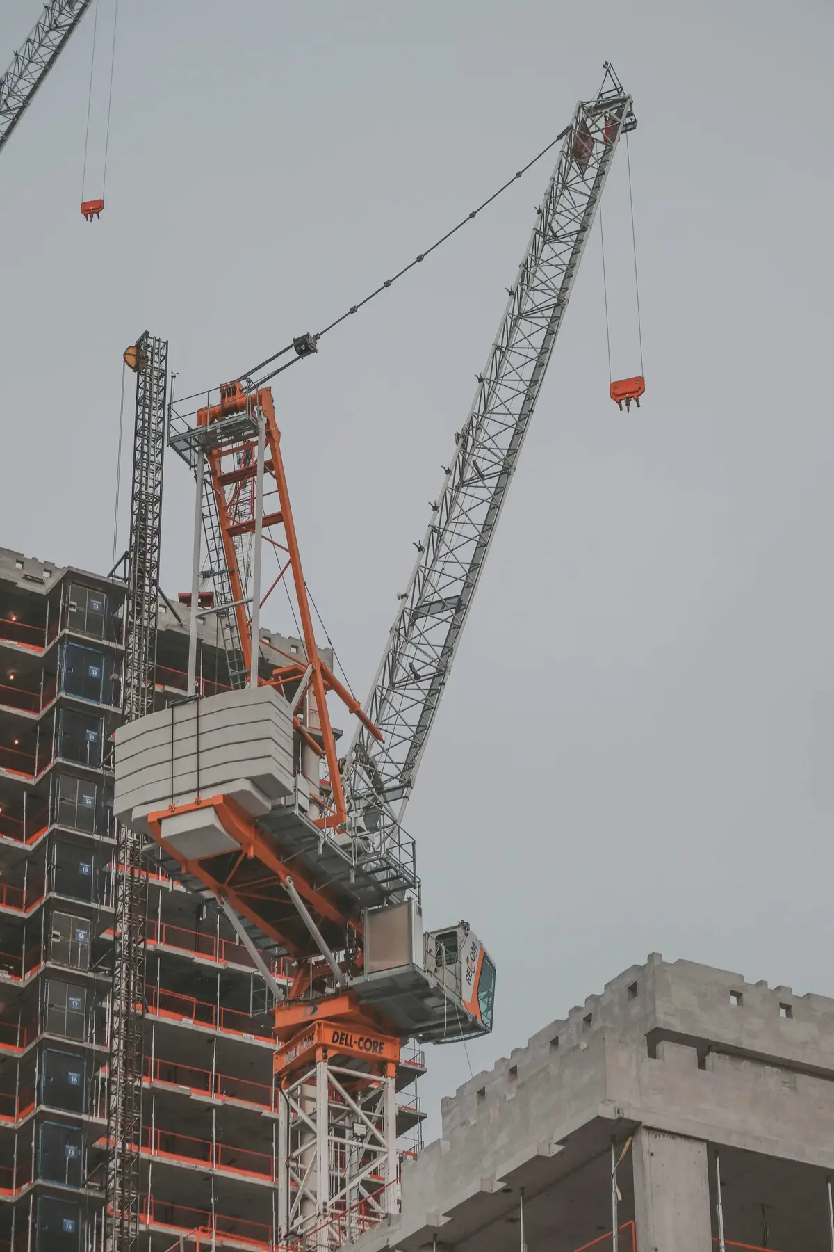 A tower crane rising beside a building under construction