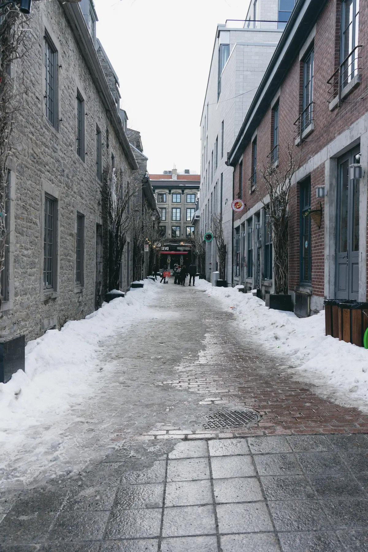 A narrow snow-covered lane between stone buildings in Vieux-Montréal