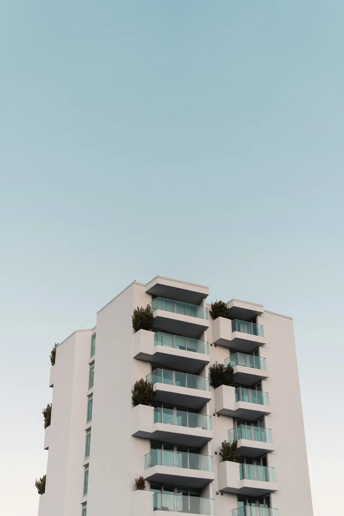 A pale apartment building with balconies against a clear sky