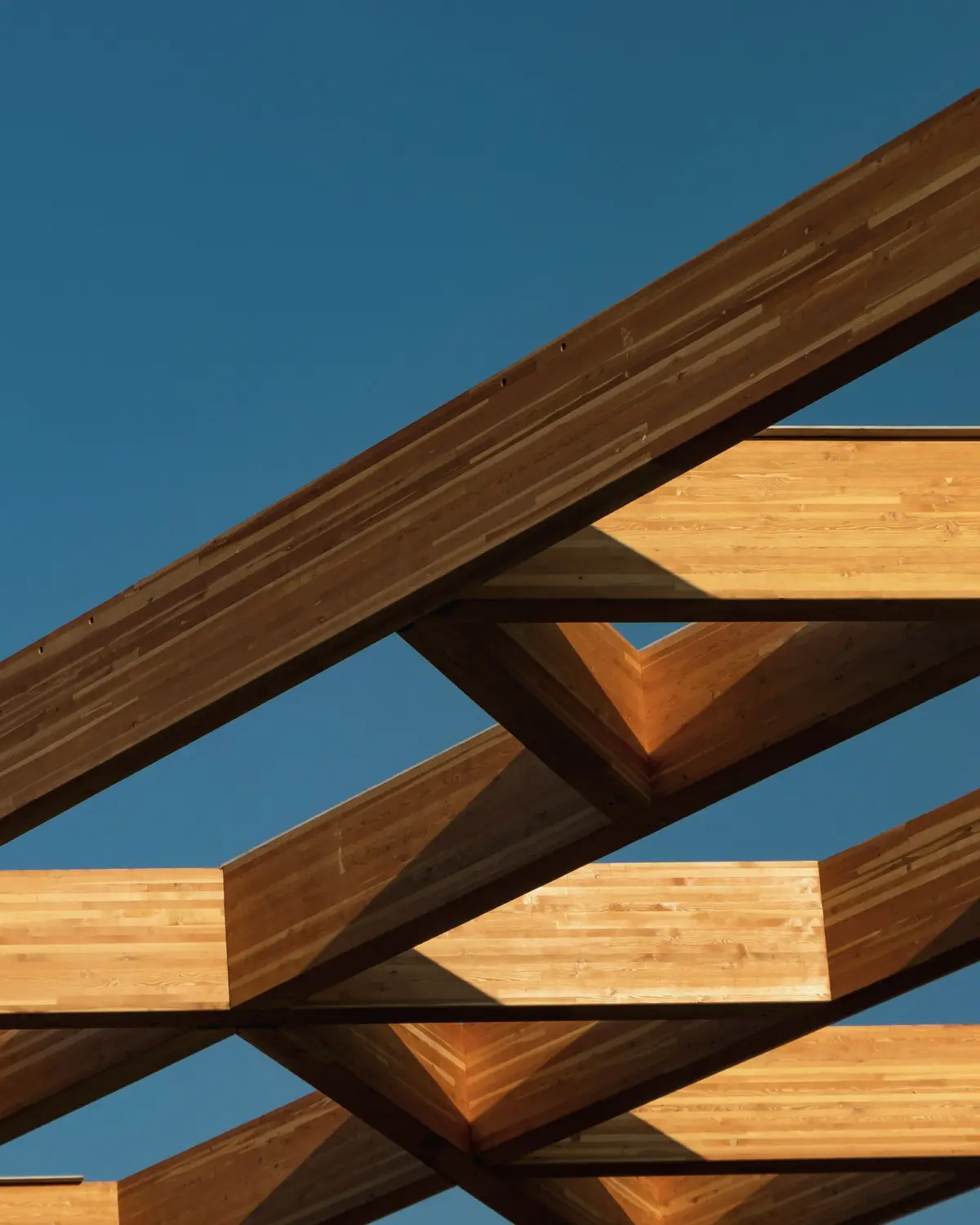 Laminated timber beams against a blue sky