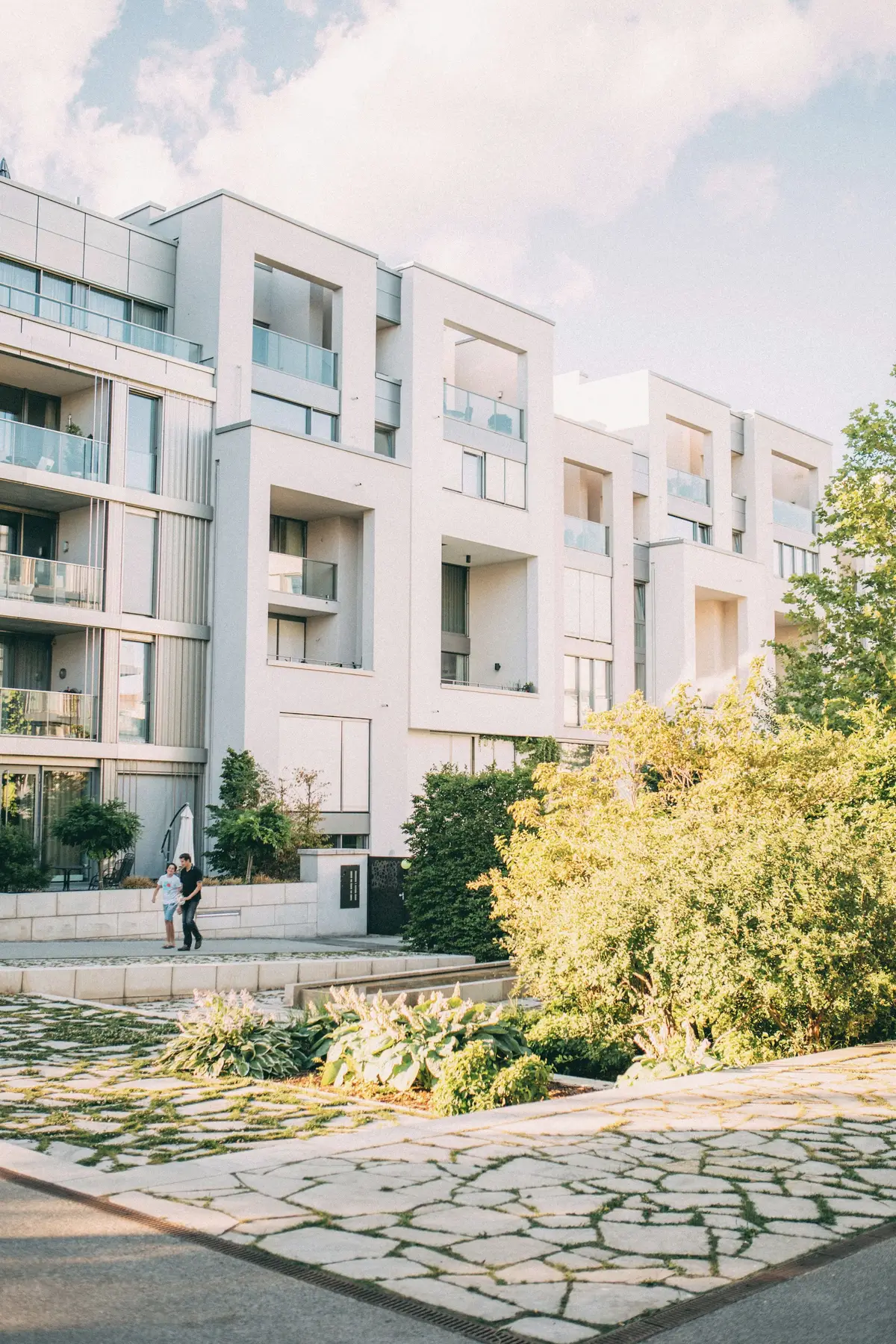 Light residential buildings stepping along a landscaped street